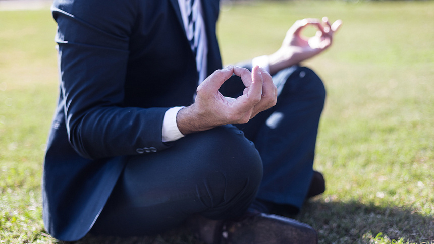 Мужчина в костюме в позе медитации фото